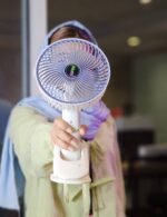 پنکه کلیپسی چند حالته نصب‌شده روی نرده کنار تخت کودک